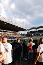 a crowd of people standing around a soccer field