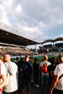 a crowd of people standing around a soccer field