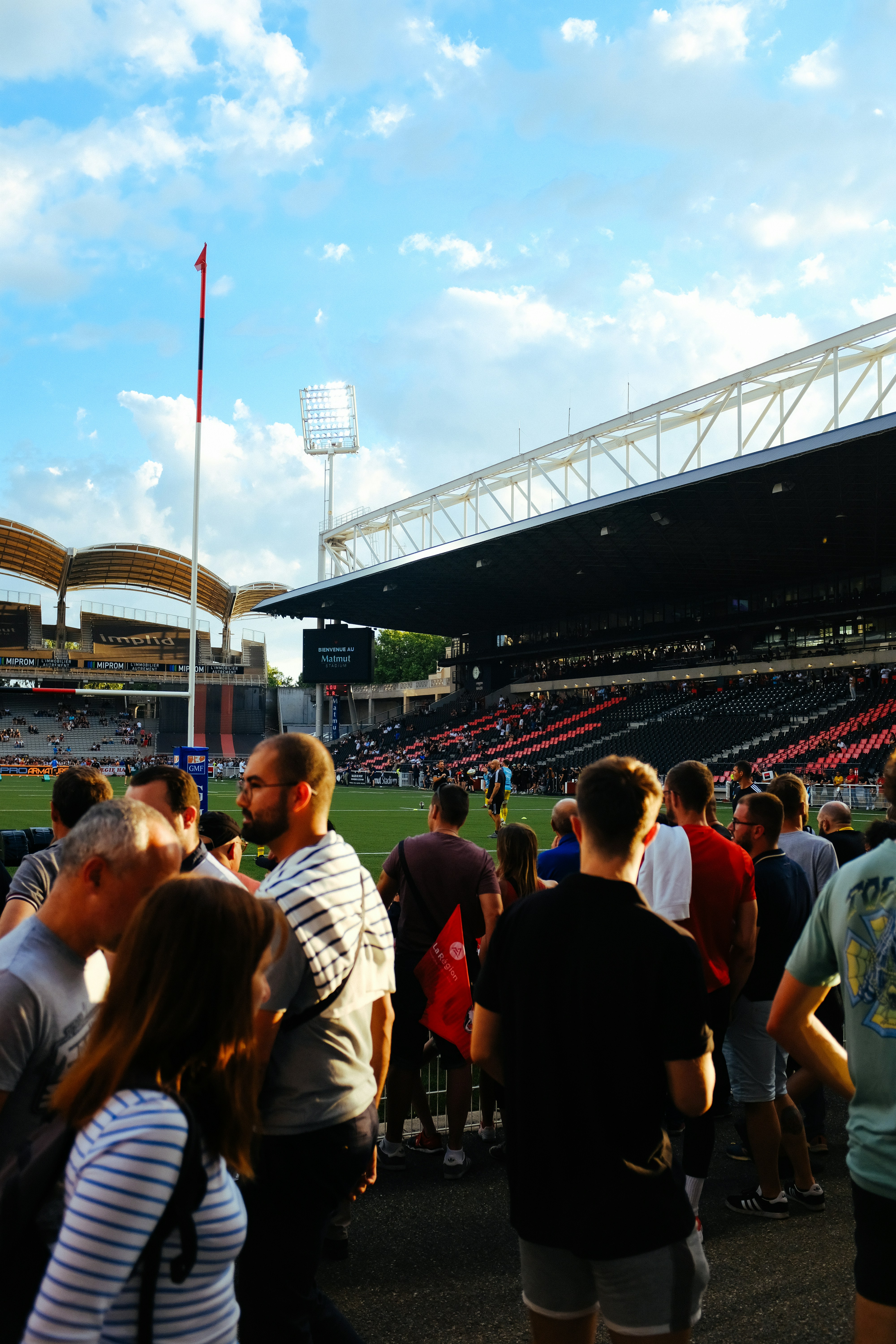 Rugby stadium with crowd under stadium lights, energetic atmosphere