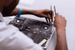 a man working on a laptop with a pair of scissors