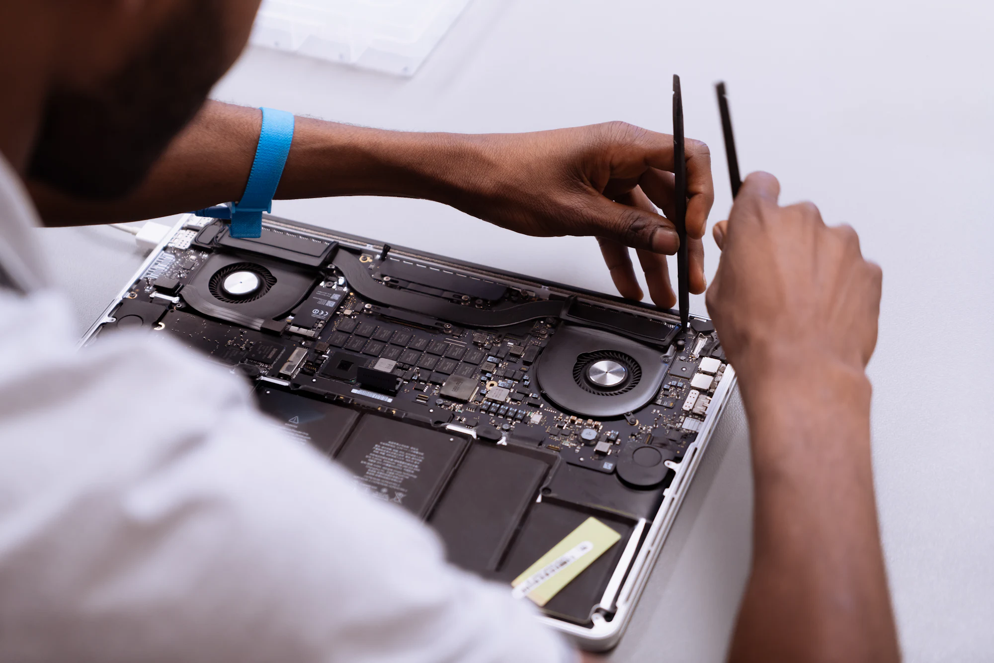 Technician working on a laptop at a repair bench