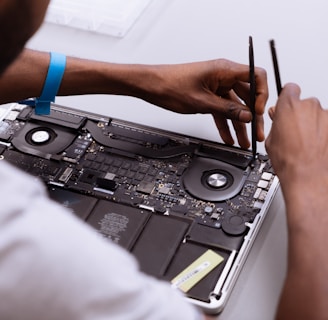 a man working on a laptop with a pair of scissors