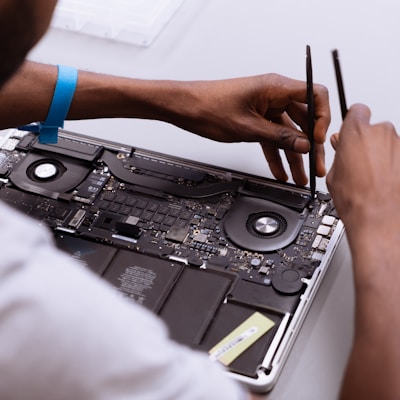 a man working on a laptop with a pair of scissors