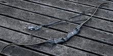 a broken umbrella sitting on top of a wooden bench