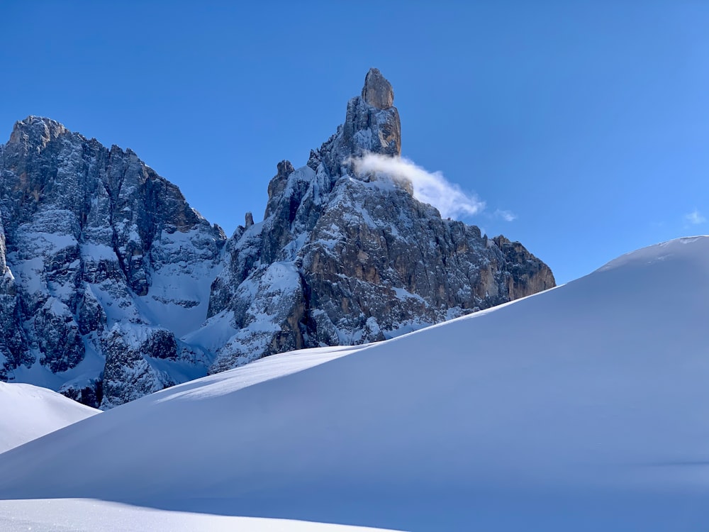 a mountain range covered in snow under a blue sky