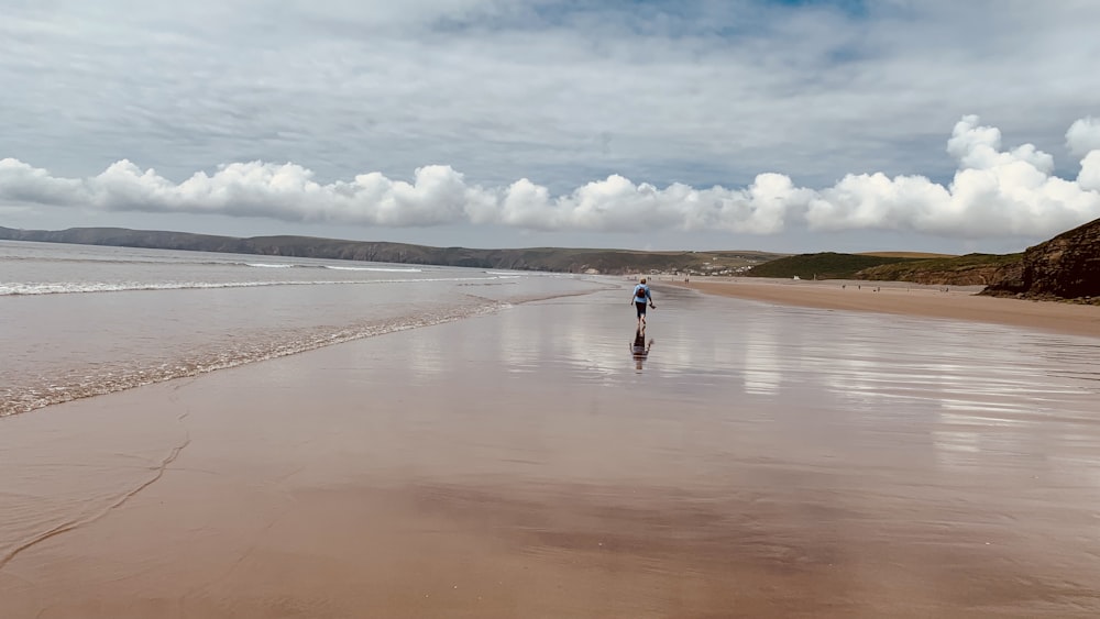 a person walking on a beach near the ocean