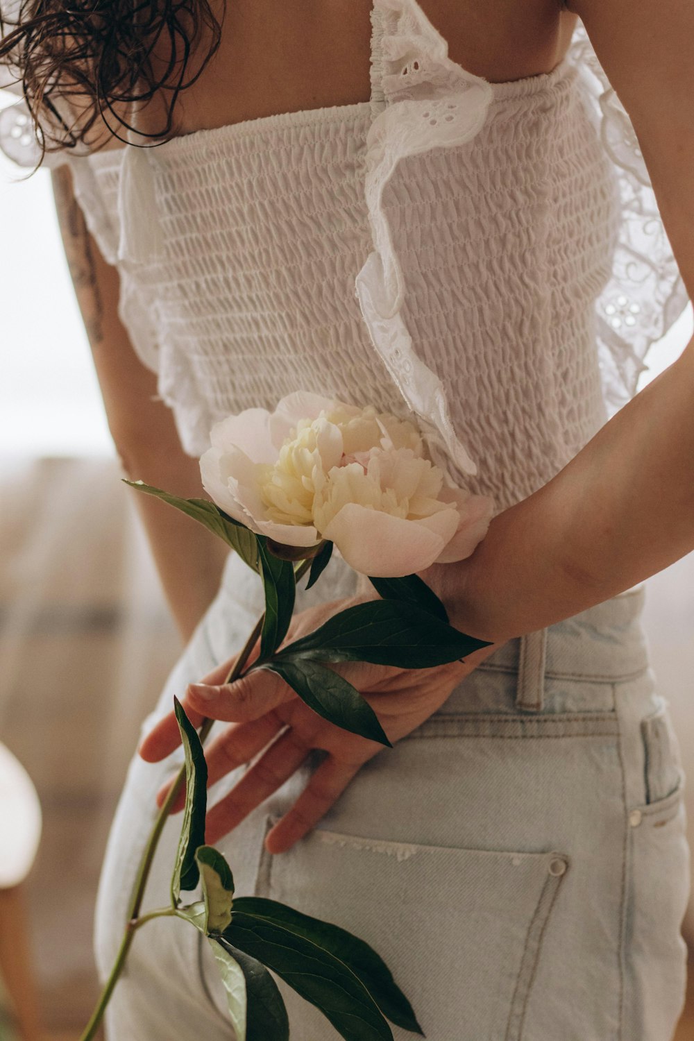 a woman is holding a flower in her hand