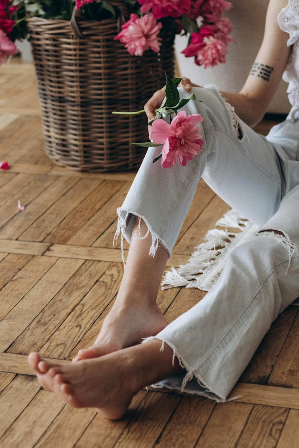 a woman sitting on the floor holding a flower