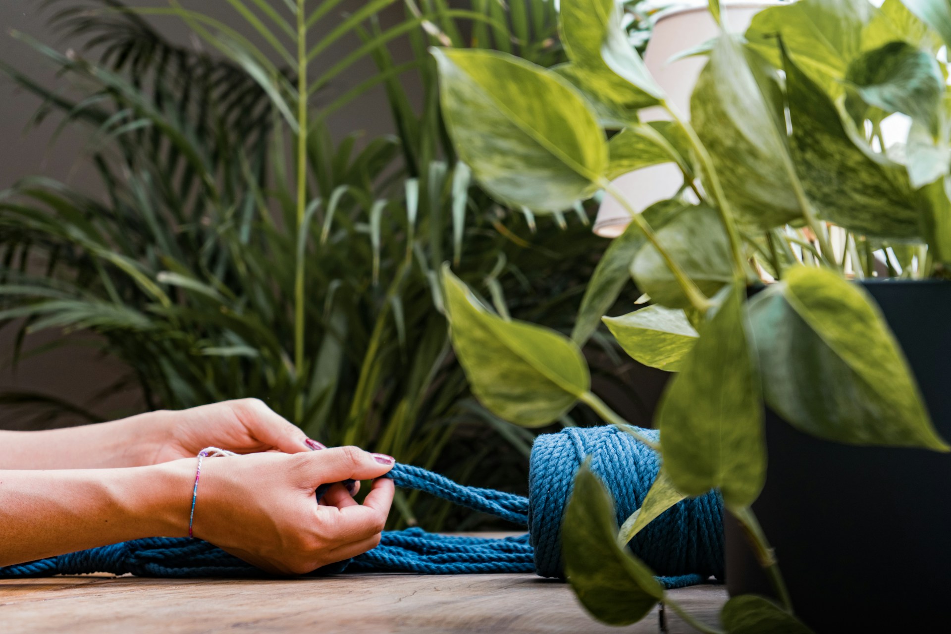 a person tying a blue rope on a table