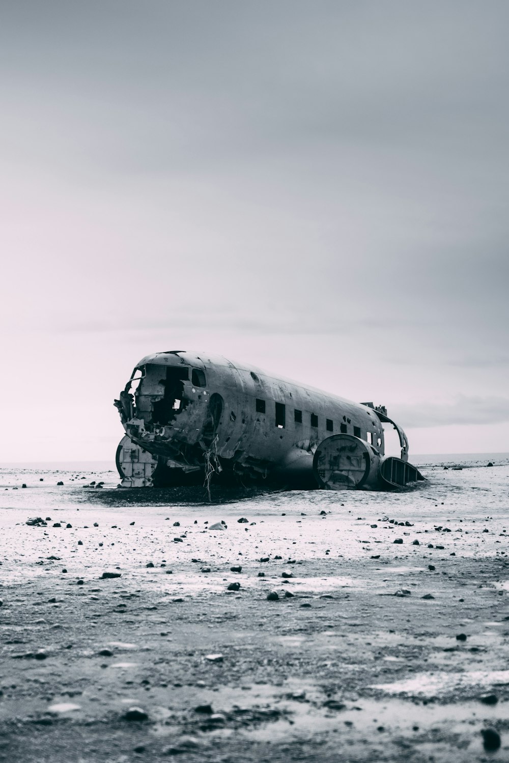 Un vieil avion assis au sommet d’une plage de sable