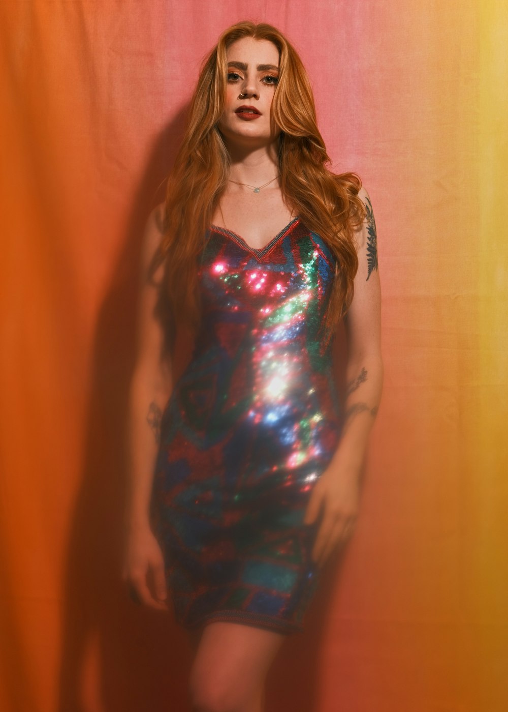 a woman with red hair wearing a shiny dress