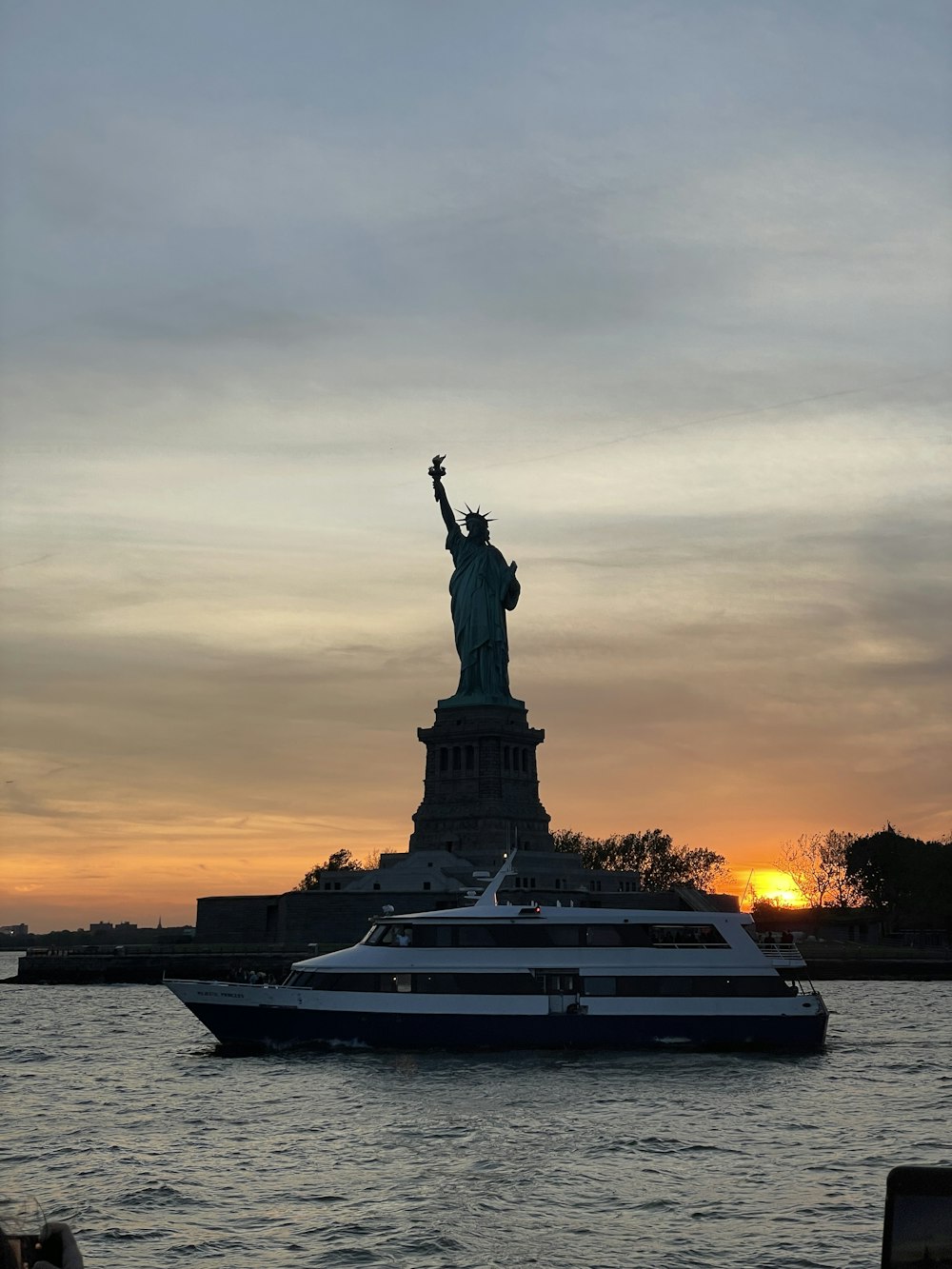 a boat in the water near a statue of liberty
