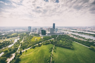 Aerial view of a modern city skyline with green spaces and sustainable transport options.