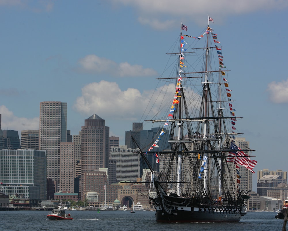 a large boat sailing in the water with a city in the background