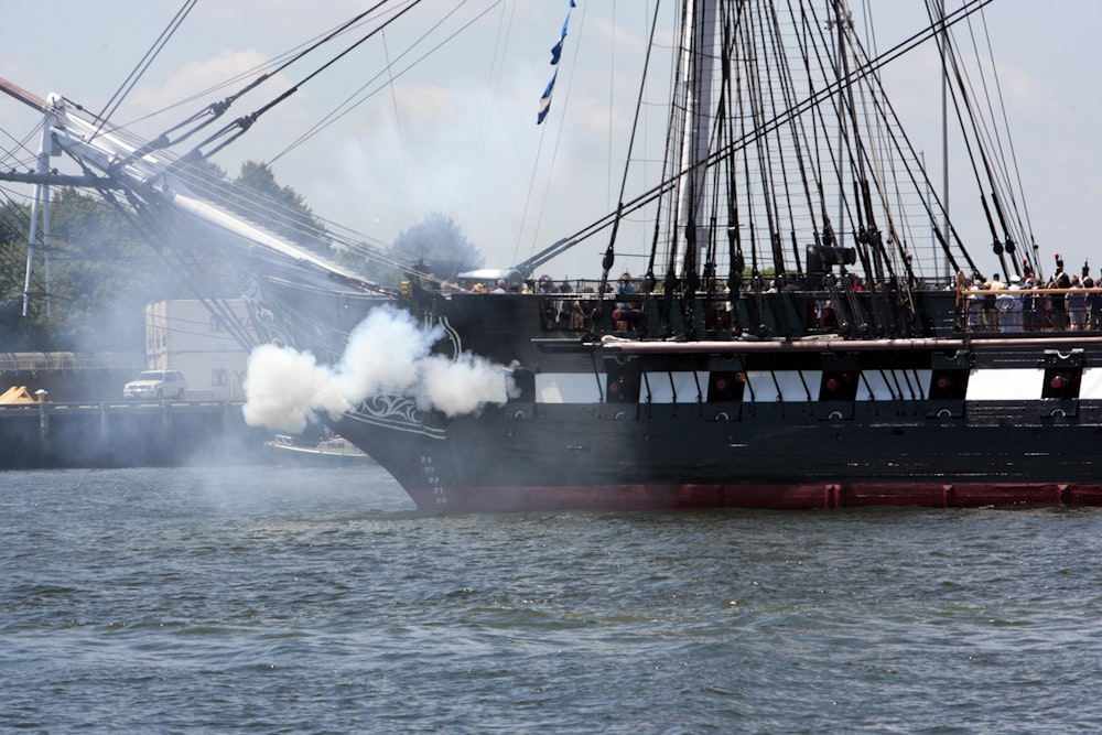 smoke billows from a ship in the water