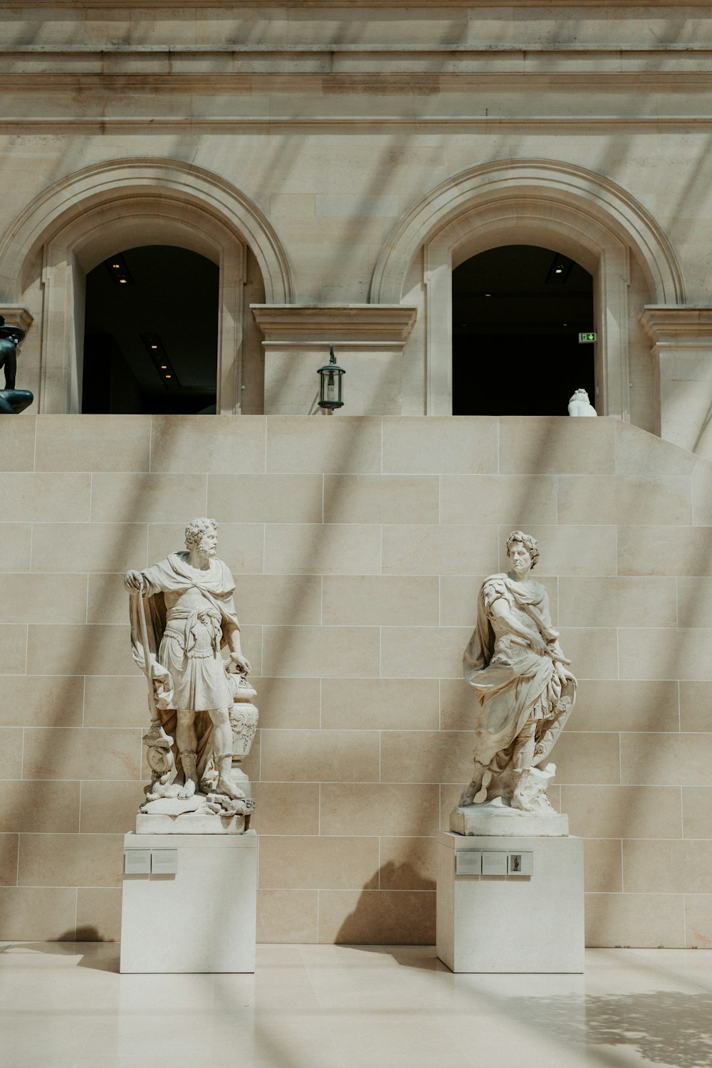 un couple de statues assises l’une à côté de l’autre