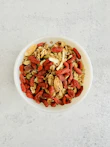 A bowl filled with crunchy, nutritious trail mix with nuts and dried fruit