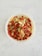 A bowl filled with a mixture of various nuts, seeds, and dried fruits, including almonds, walnuts, pumpkin seeds, and red goji berries. The bowl is placed on a light-colored, textured surface.