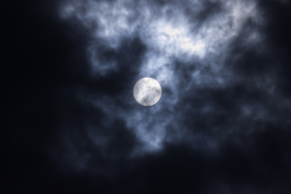 a full moon seen through a cloudy sky