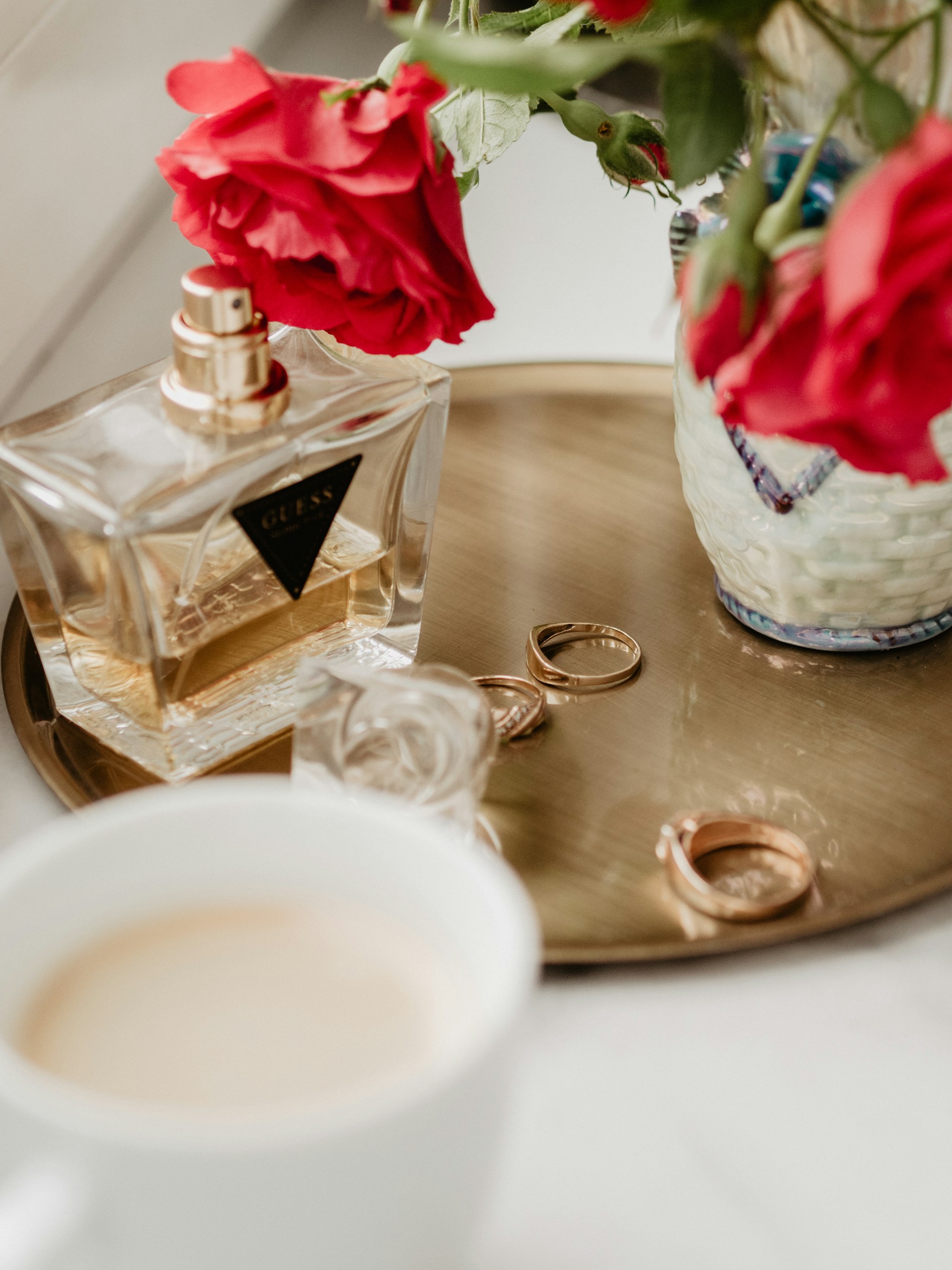 a table with a cup of coffee and a bottle of perfume