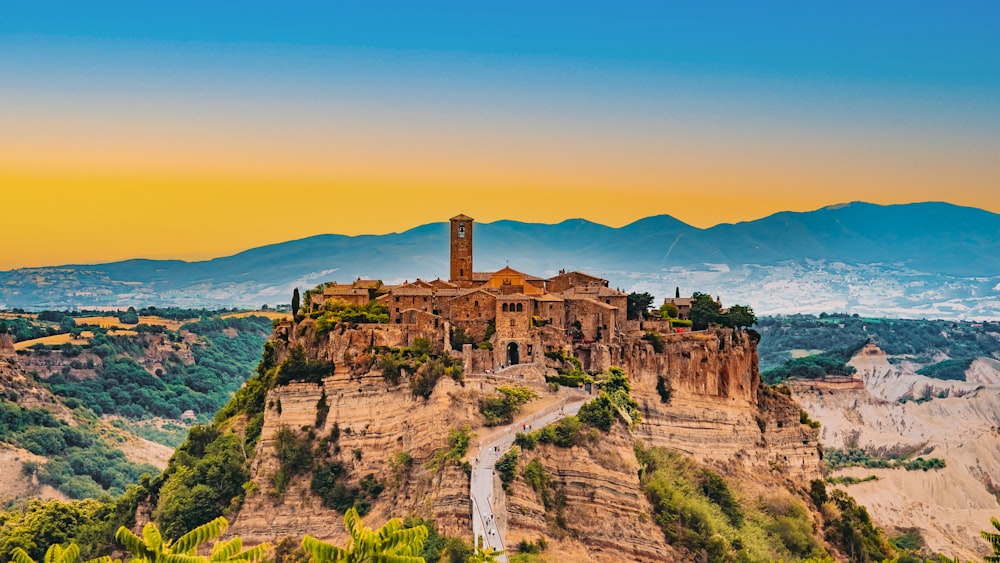 Un castello sulla cima di una montagna circondata da alberi