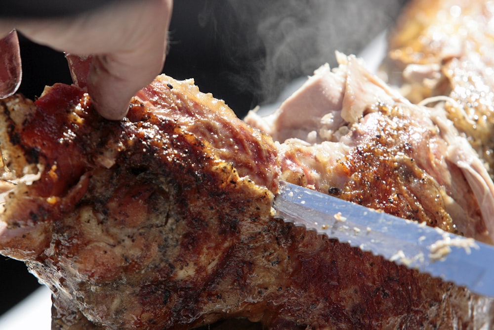 a person is cutting meat with a knife