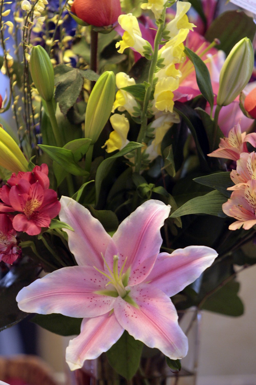 a vase filled with lots of different colored flowers