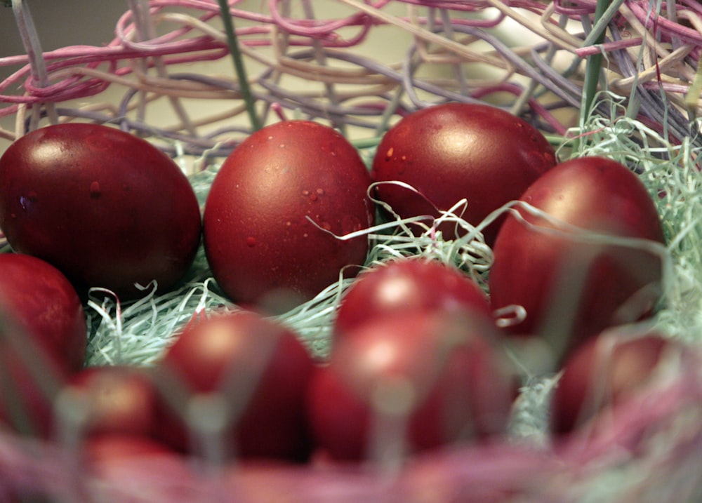 a basket filled with red eggs sitting on top of a table
