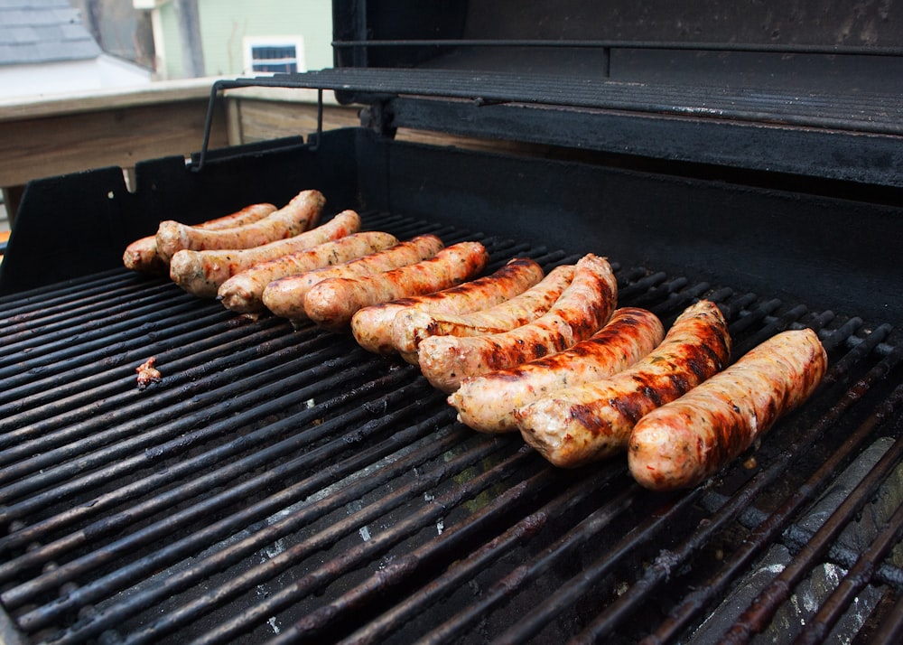 a bunch of sausages are cooking on a grill