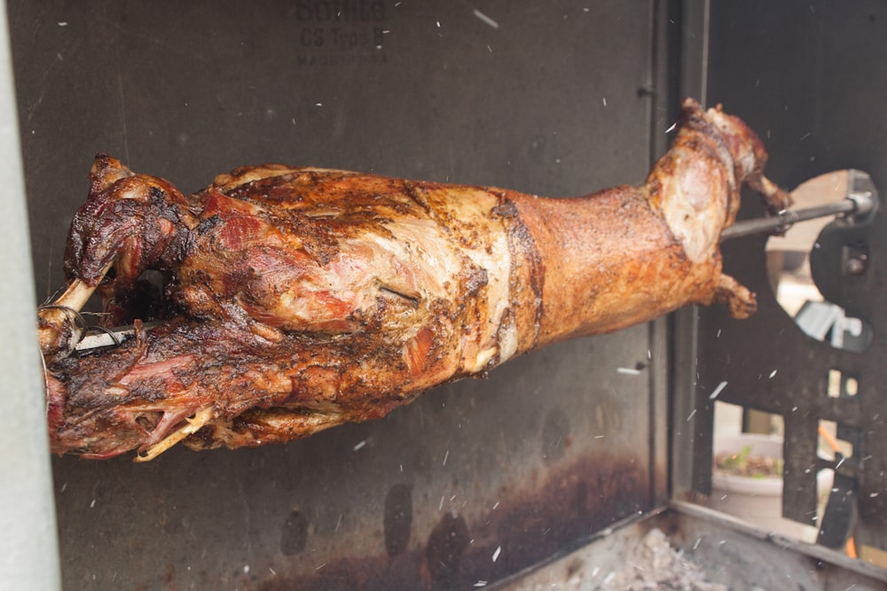 a large piece of meat is being cooked on a grill