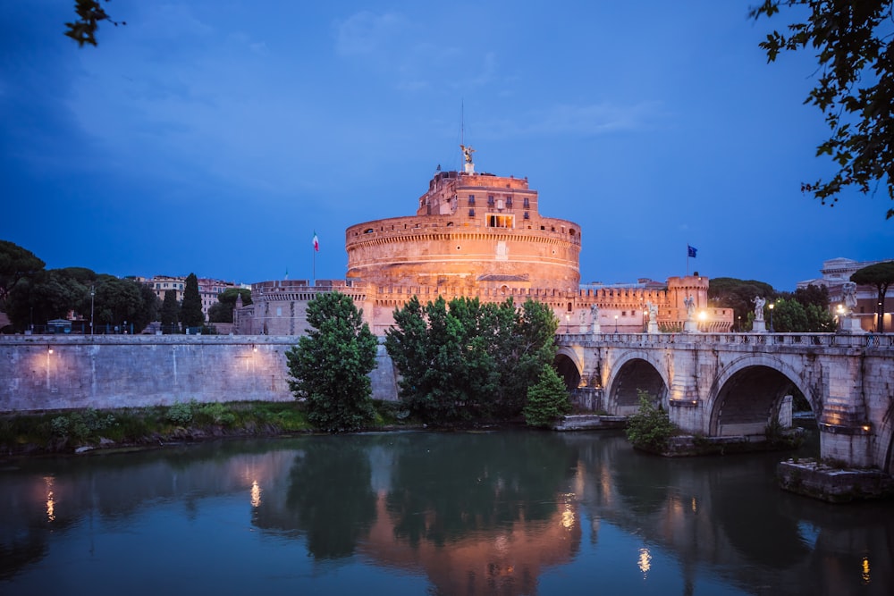 a large building sitting on top of a river next to a bridge