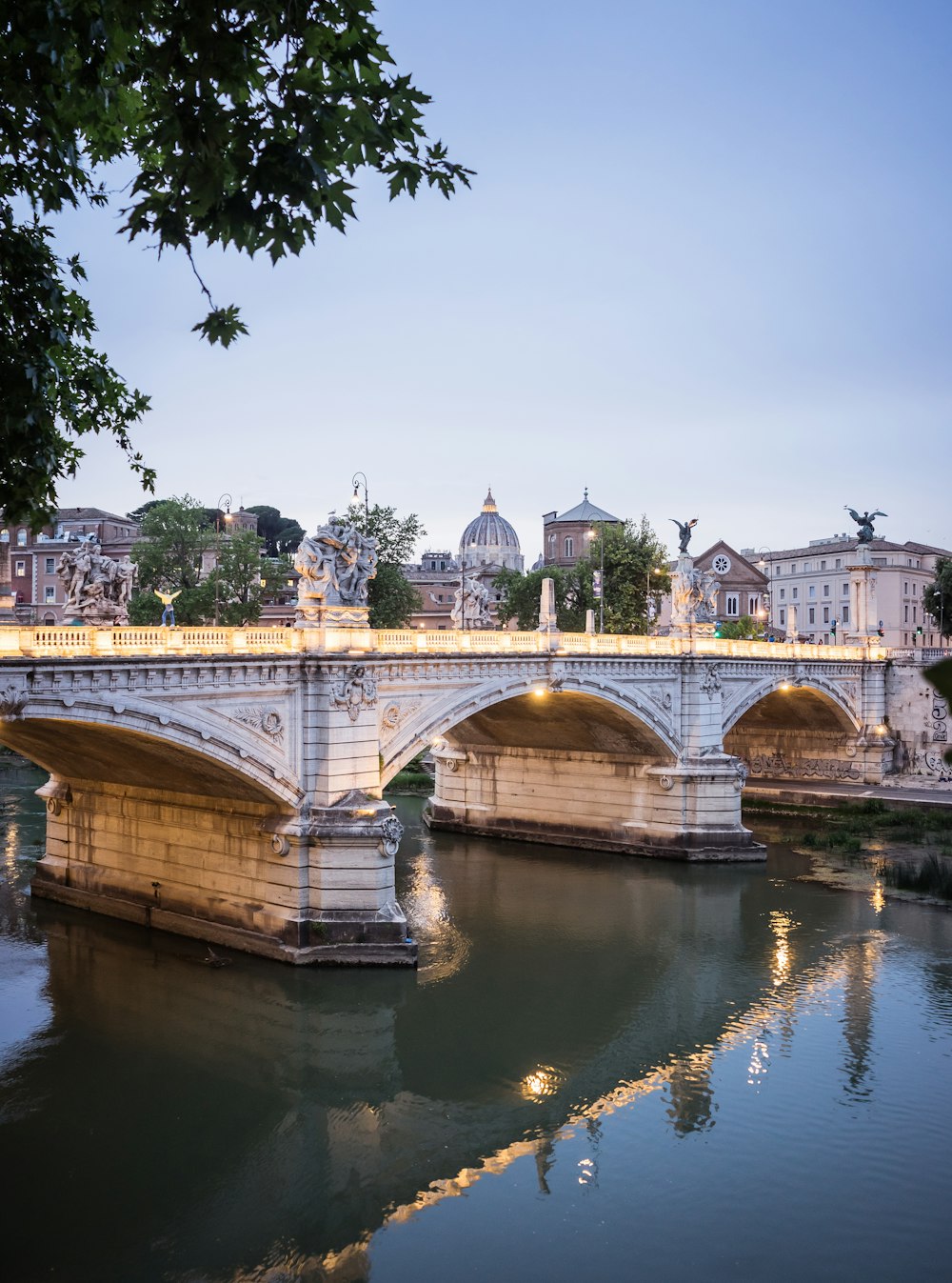 a bridge over a body of water with buildings in the background