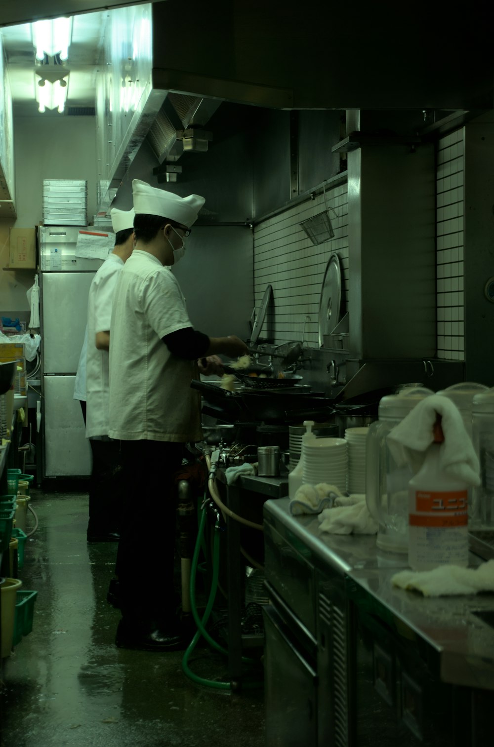 two chefs in a commercial kitchen preparing food