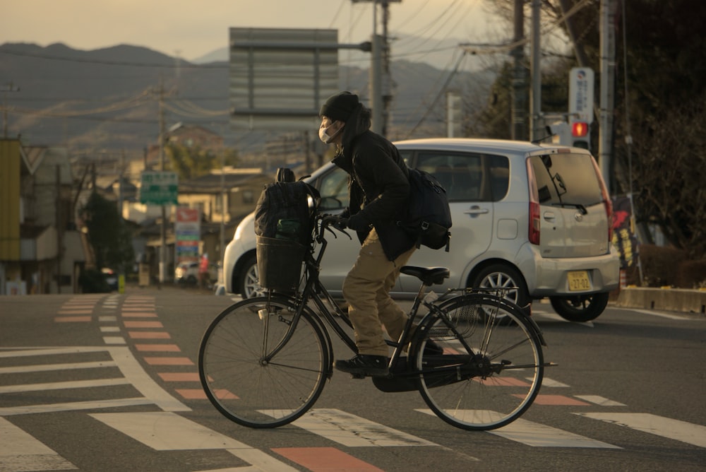通りを横切って自転車に乗る男