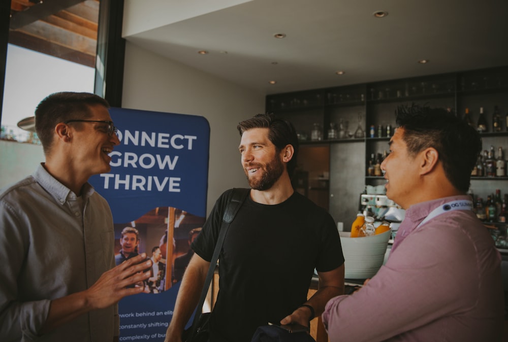 a group of three men standing next to each other