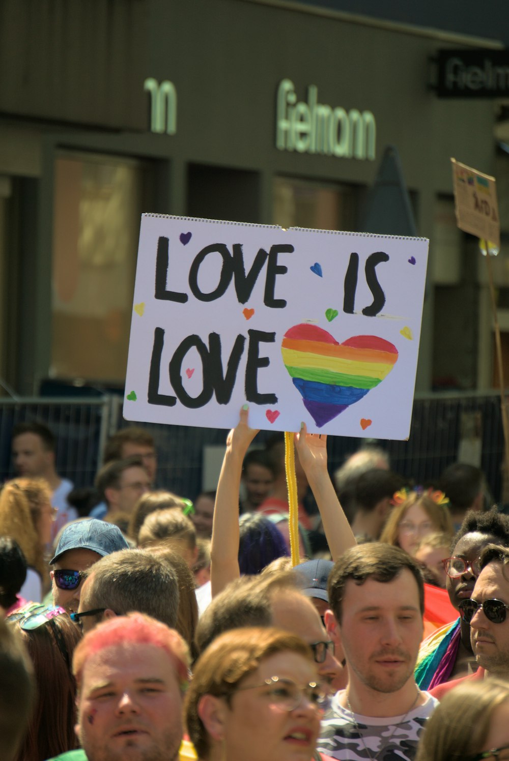 a crowd of people holding a sign that says love is love