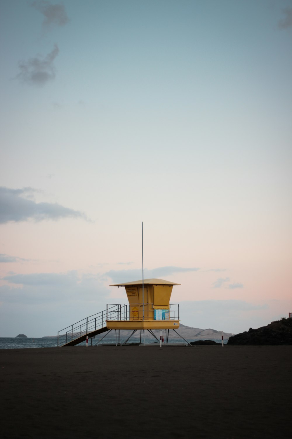 a lifeguard tower sitting on top of a sandy beach