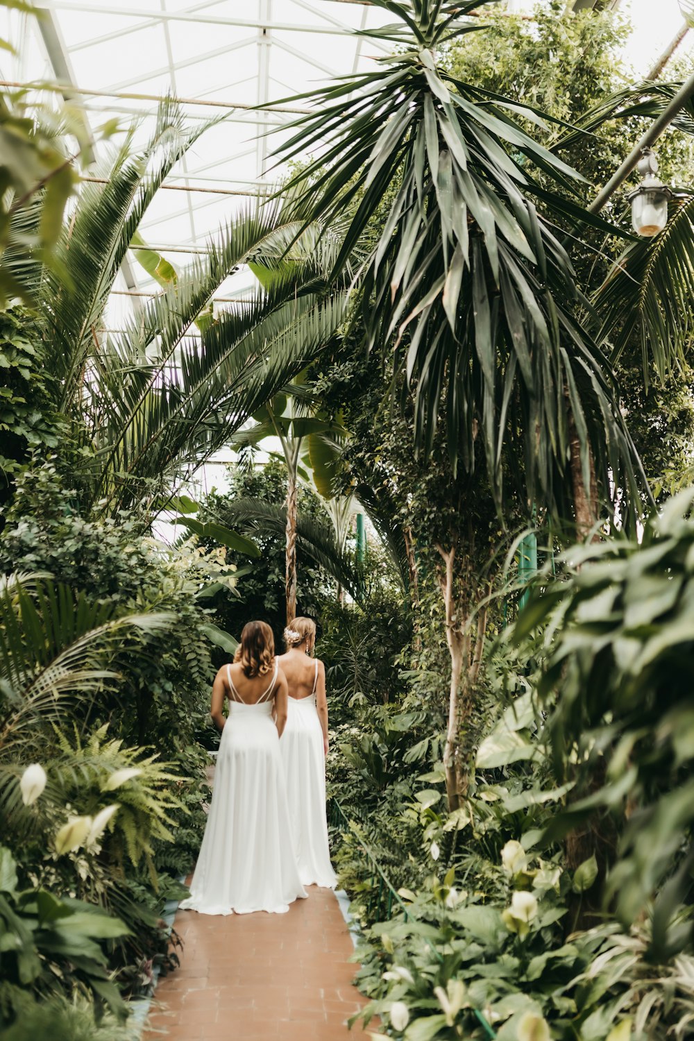 a couple of women standing next to each other in a forest