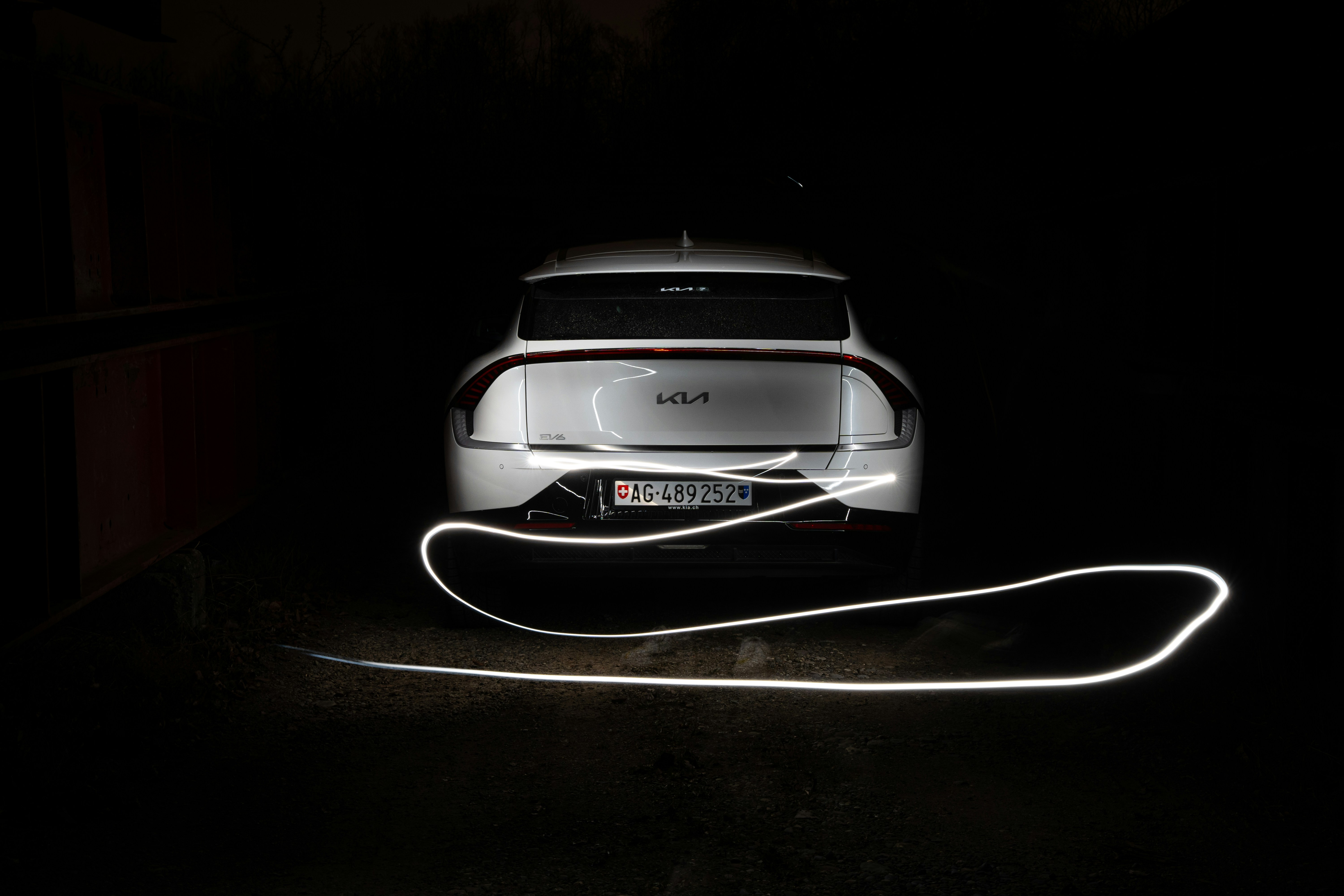 Une voiture garée dans le noir avec ses phares allumés