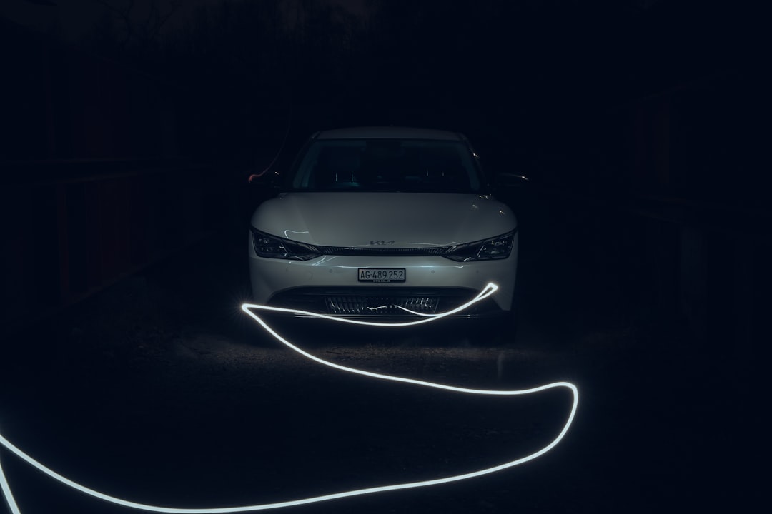 a car is parked in the dark with its headlights turned on,
