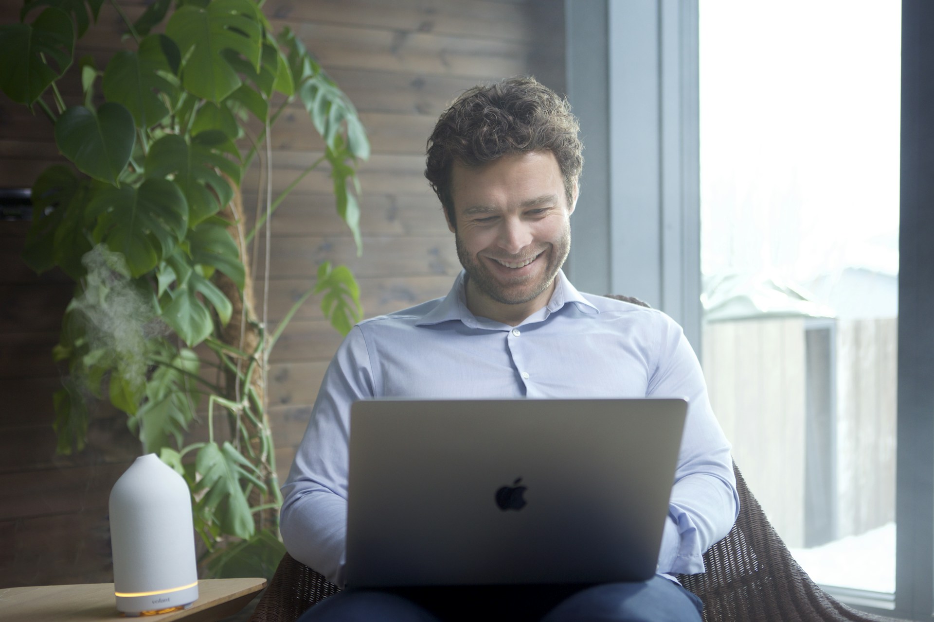 a man sitting in a chair using a laptop computer