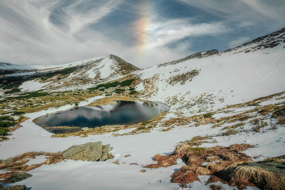 a rainbow in the sky over a snow covered mountain