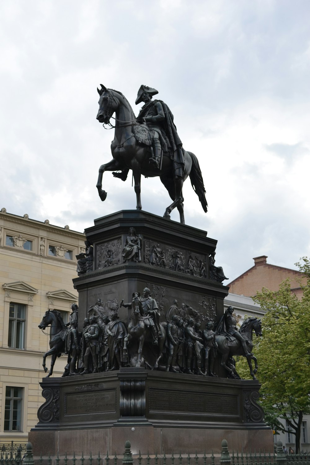 Eine Statue eines Mannes auf einem Pferd vor einem Gebäude