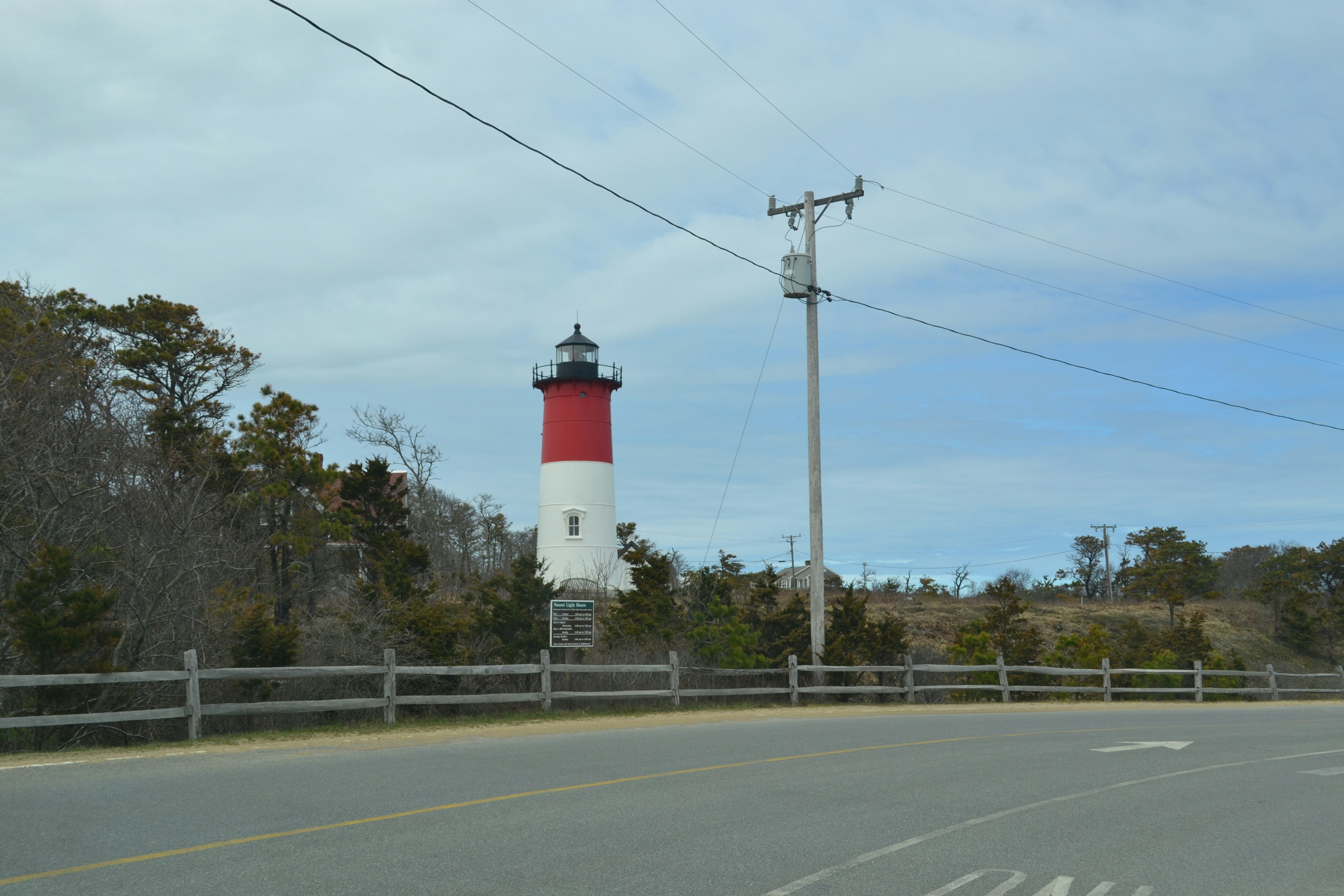 a red and white light house sitting on the side of a road