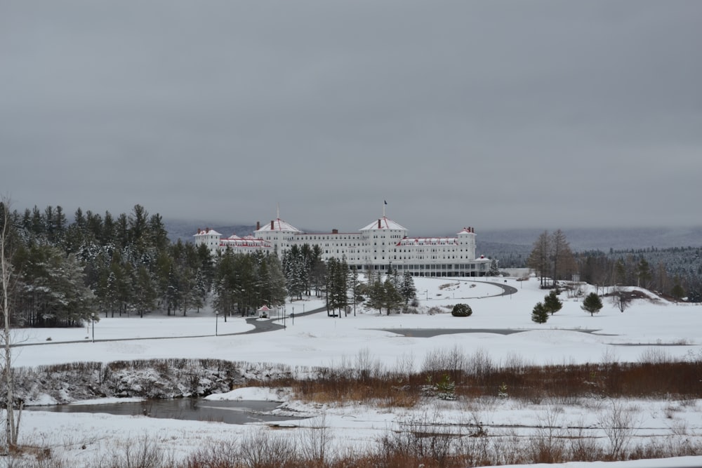 a large white building sitting on top of a snow covered field