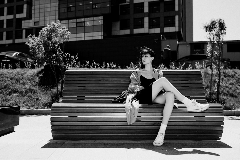 a woman sitting on a bench in a park