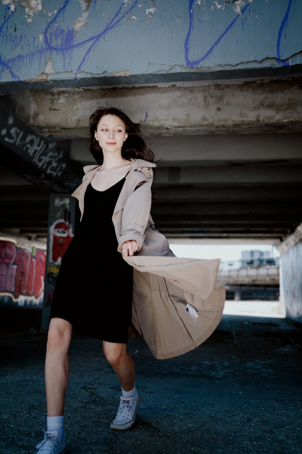 a woman in a black dress and a trench coat