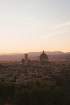 A panoramic view of Toledo's historic skyline at sunset with warm golden light.