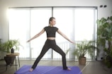a woman standing on a yoga mat in a room