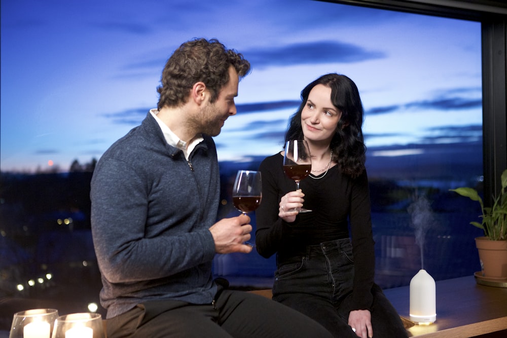 a man and a woman holding wine glasses